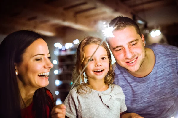 Ung familj med tomtebloss i juletid hemma. — Stockfoto