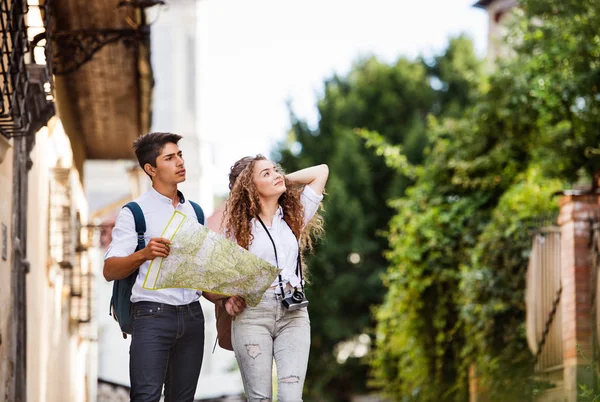 Two young tourists with map and camera in the old town — Stock Photo, Image