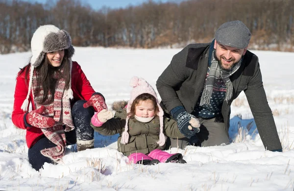Батько, мати та їхня донька розважаються в зимовій природі . — стокове фото