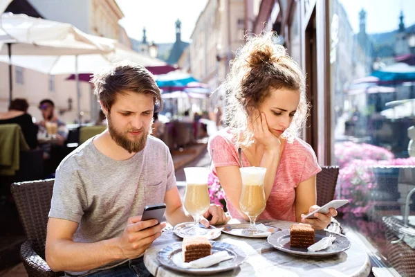 젊은 커플 스마트폰 카페에 앉아. — 스톡 사진