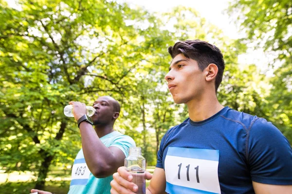 Два молодых спортсмена готовились к бегу, питьевой воде . — стоковое фото