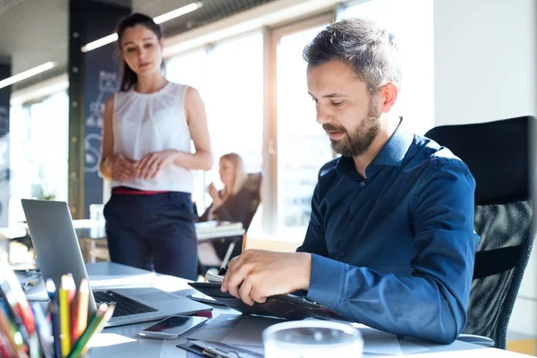 Drei Geschäftsleute im Büro arbeiten zusammen. — Stockfoto