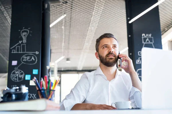 Geschäftsmann mit Smartphone und Kaffee im Büro. — Stockfoto