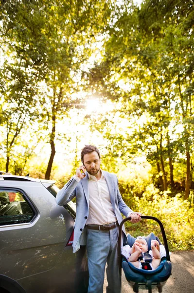 Unga far med sin lilla bebis som kommer in i bilen. — Stockfoto