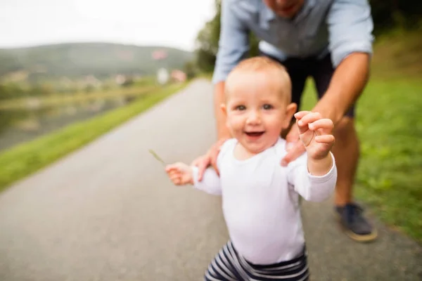 Liten pojke med far att göra första stegen i naturen. — Stockfoto