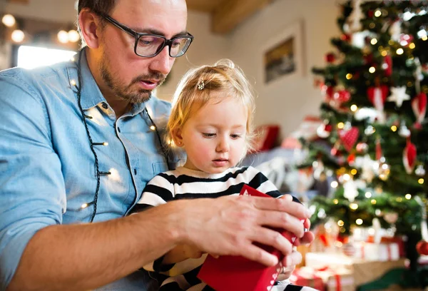 Menina com seu pai abrindo presente de Natal . — Fotografia de Stock