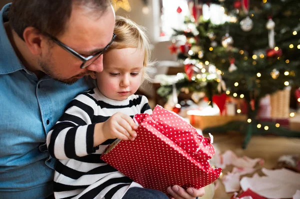 Küçük kız babasıyla Noel hediyesi açma.