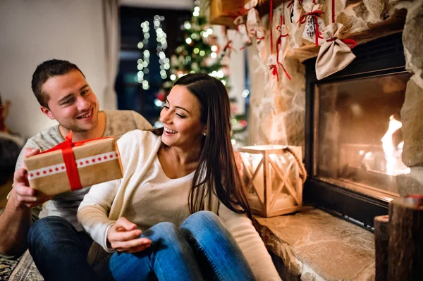 Um casal em frente à lareira. Tempo de Natal . — Fotografia de Stock