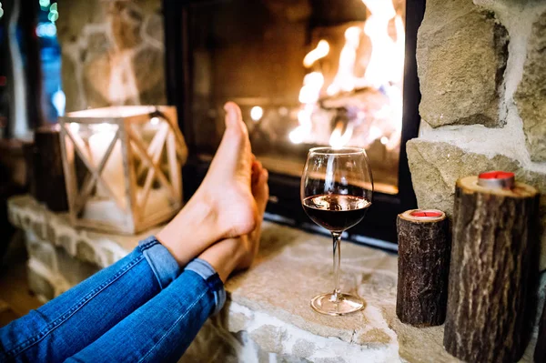 Pies de mujer irreconocible frente a la chimenea . —  Fotos de Stock