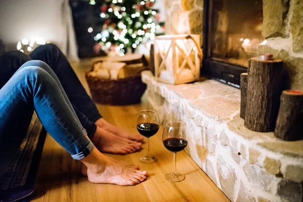 Beine von Frau und Mann vor dem Kamin unkenntlich gemacht. — Stockfoto