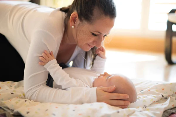 Beautiful mother holding head of her cute baby son — Stock Photo, Image
