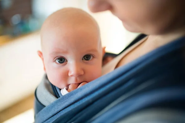 Unrecognizable young mother with her son in sling — Stock Photo, Image