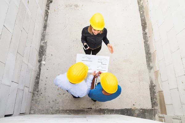 Architects and worker at the construction site. — Stock Photo, Image