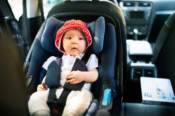 Kis baba rögzítve, biztonsági öv, a biztonsági autósülés. — Stock Fotó