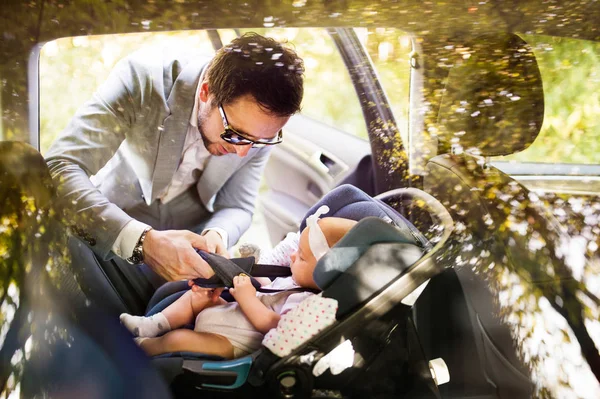 Unga far sättande flicka i bilen. — Stockfoto