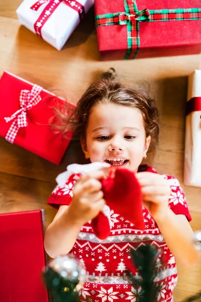 Petite fille couchée sur le sol parmi les cadeaux . — Photo