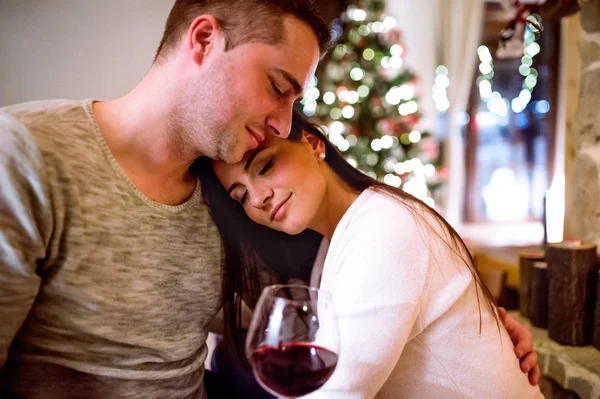 Casal sentado na frente da lareira, bebendo vinho . — Fotografia de Stock