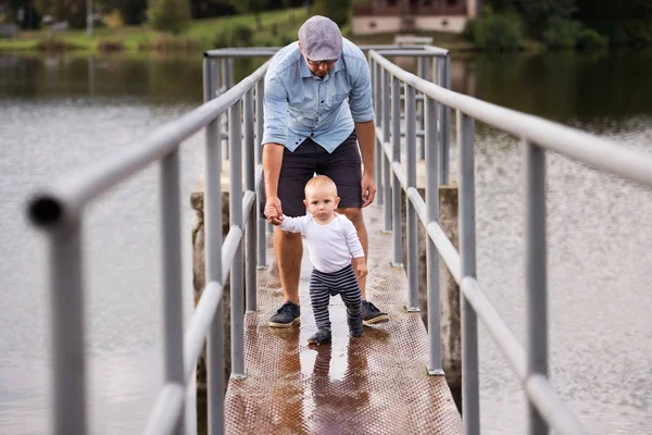 Jongetje met vader eerste stappen maken in de natuur. — Stockfoto