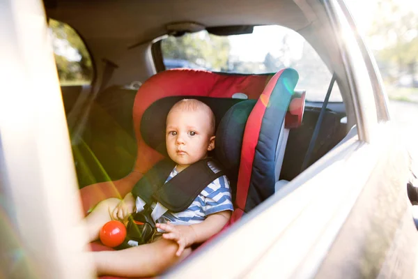 Petit garçon assis dans le siège auto dans la voiture . — Photo