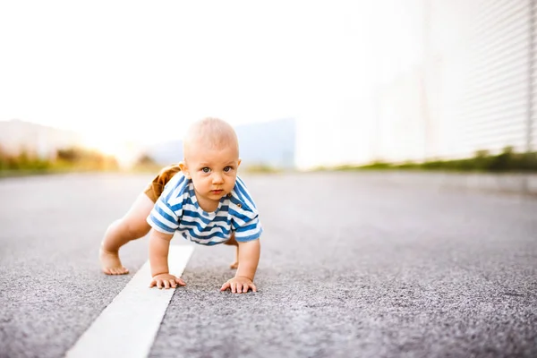 Baby jongetje kruipen buiten op de weg. — Stockfoto