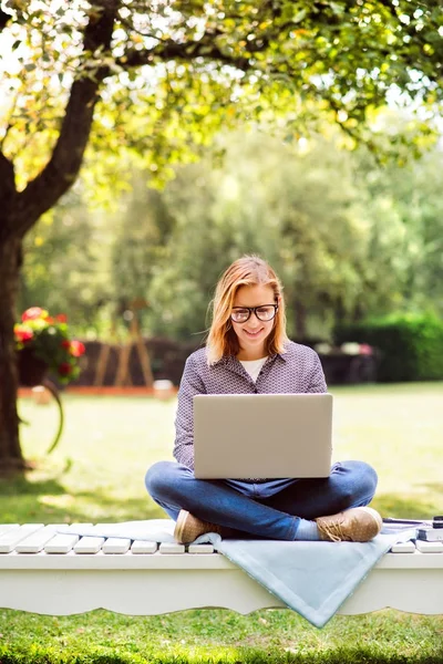 Young woman with a laptop studying outdoors. — Stock Photo, Image