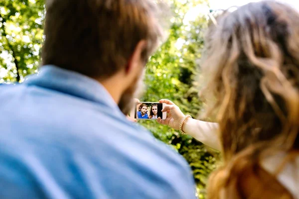 Unga par med smartphone tar selfie. — Stockfoto