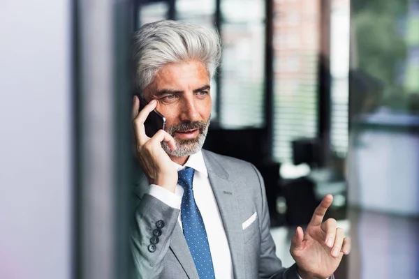 Uomo d'affari maturo con smartphone in ufficio . — Foto Stock