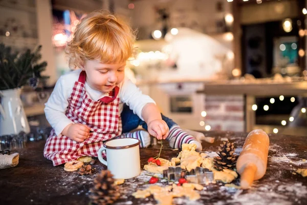 Peuter jongen maken van peperkoek cookies thuis. — Stockfoto