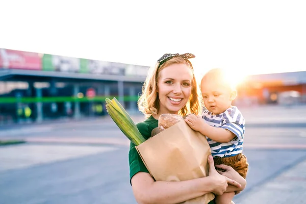 Mladá matka s chlapeček u supermarketu. — Stock fotografie