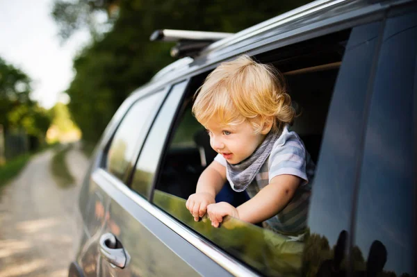 Petit garçon jouant dans la voiture, penché par la fenêtre . — Photo