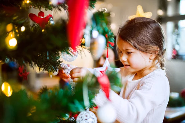 Kis lány díszítő karácsonyfa. — Stock Fotó