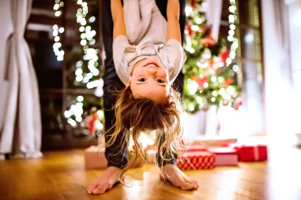 Baba ile kızı Noel ağacı onu baş aşağı tutarak. — Stok fotoğraf