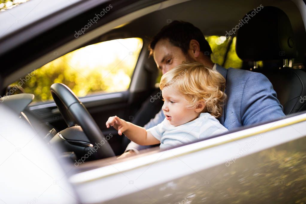 Man driving a car with little son.