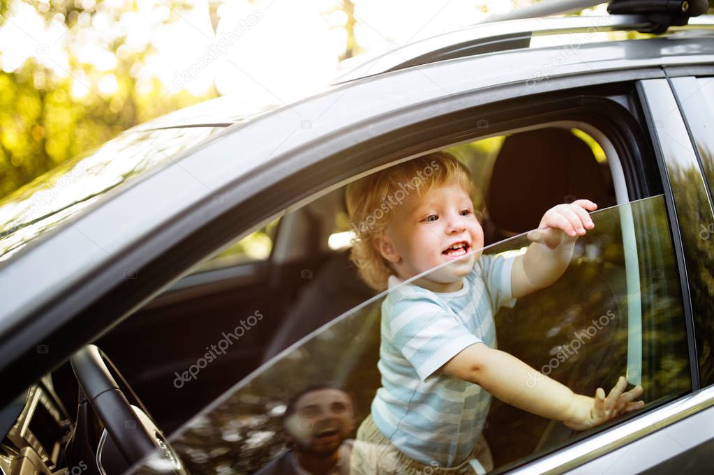 Little boy in the car, looking out of window.