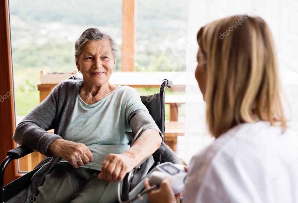 Health visitor and a senior woman during home visit.