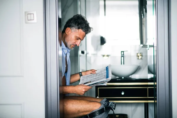 Mature businessman in a hotel room bathroom. — Stock Photo, Image