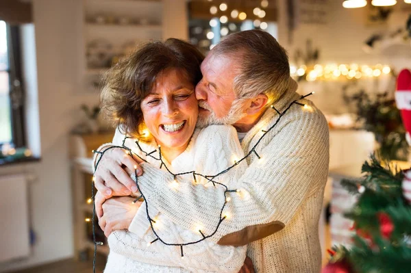 Senior couple hugging at home at Christmas time. — Stock Photo, Image
