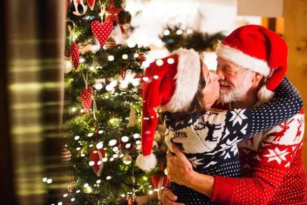 Casal sênior com chapéus de Papai Noel no Natal . — Fotografia de Stock