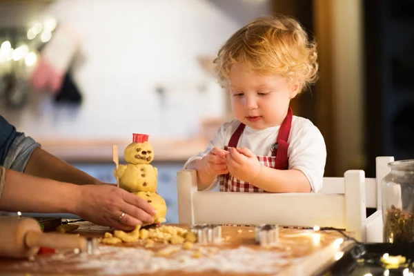 Peuter jongen maken van peperkoek cookies thuis. — Stockfoto