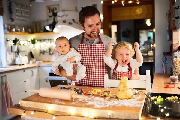 Jonge familie maken van cookies thuis. — Stockfoto