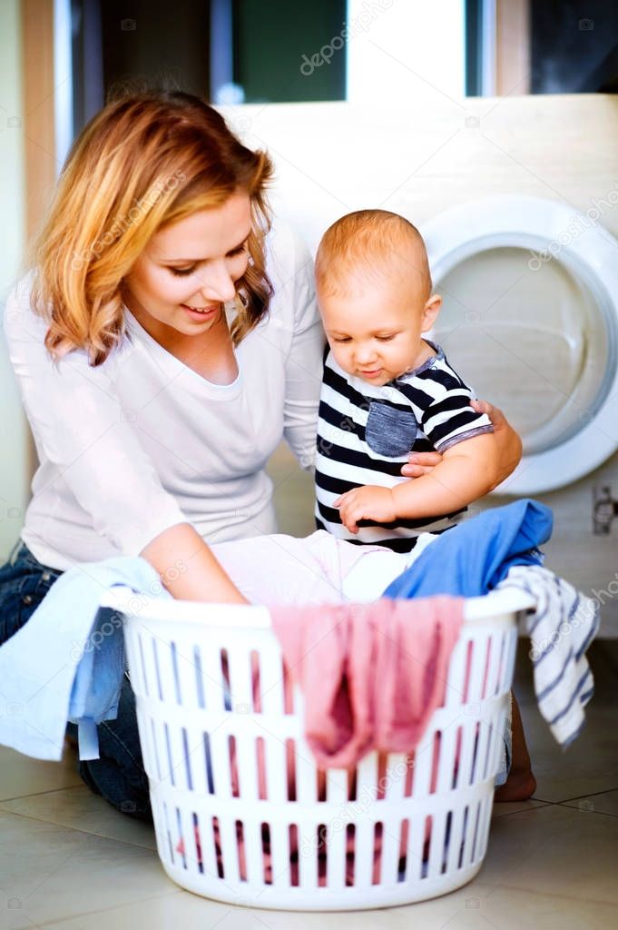 Young mother with a baby boy doing housework.