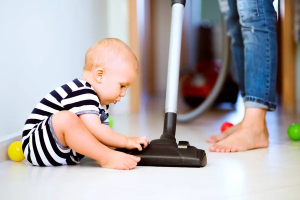 Ung mamma med en pojke som gör hushållsarbete. — Stockfoto