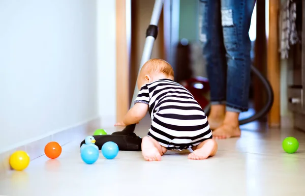 Young mother with a baby boy doing housework. — Stock Photo, Image