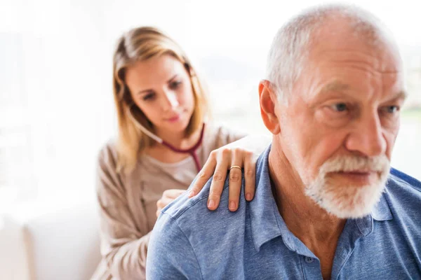 Gesundheitsbesucherin und ein älterer Mann bei Hausbesuch. — Stockfoto