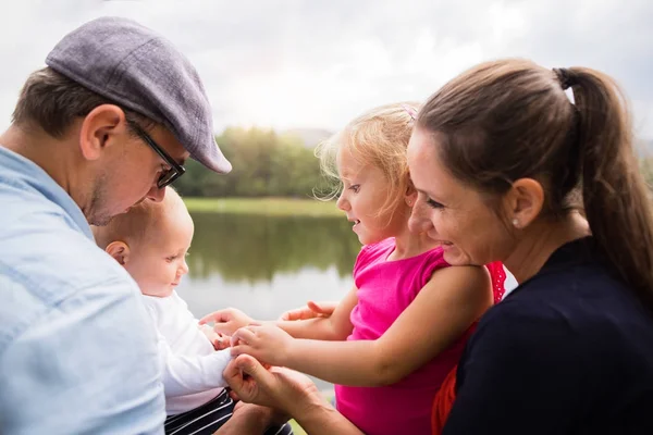 Famiglia felice nella natura in riva al lago in estate . — Foto Stock