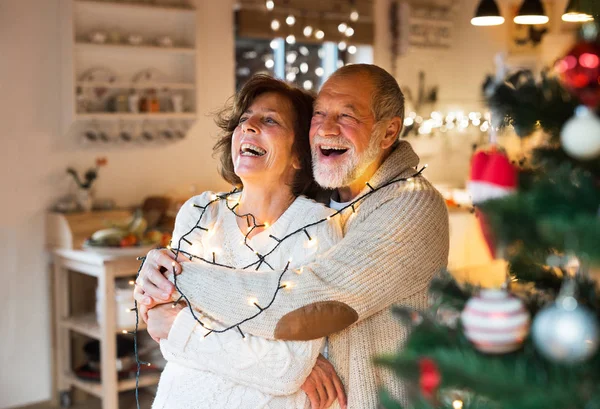 Ανώτερος ζευγάρι αγκάλιασμα στο σπίτι στο χρόνο Χριστουγέννων. — Φωτογραφία Αρχείου