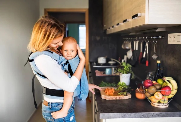 Ung mamma med en pojke som gör hushållsarbete. — Stockfoto