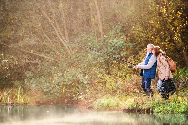 Pareja mayor pesca en el lago en otoño . —  Fotos de Stock