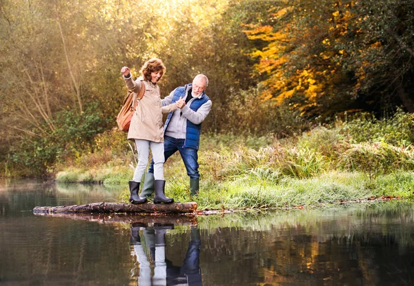 Äldre par på en promenad i höstens natur. — Stockfoto