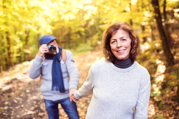 Seniorenpaar spaziert im Herbstwald. — Stockfoto